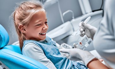 The dentist tells the child about oral hygiene and shows an artificial jaw and toothbrush. Close up view